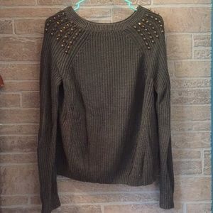 A green long sleeved top with golden studs